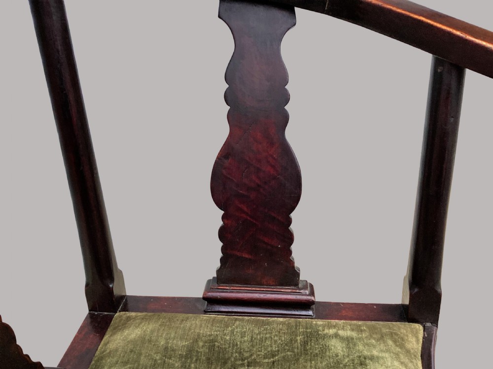 An 18th-century Chinese export dark hardwood corner armchair featuring a curved crest rail, carved splats, an olive green velvet seat, and a cabriole front leg with a carved mask and claw foot. View XI