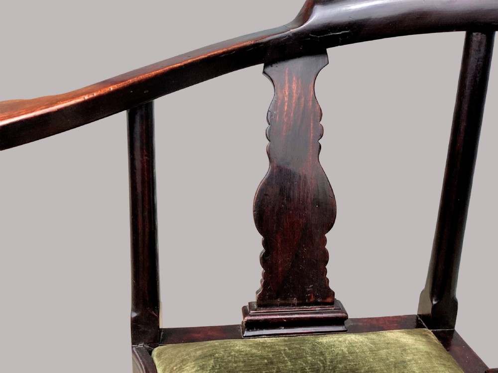 An 18th-century Chinese export dark hardwood corner armchair featuring a curved crest rail, carved splats, an olive green velvet seat, and a cabriole front leg with a carved mask and claw foot. View XII