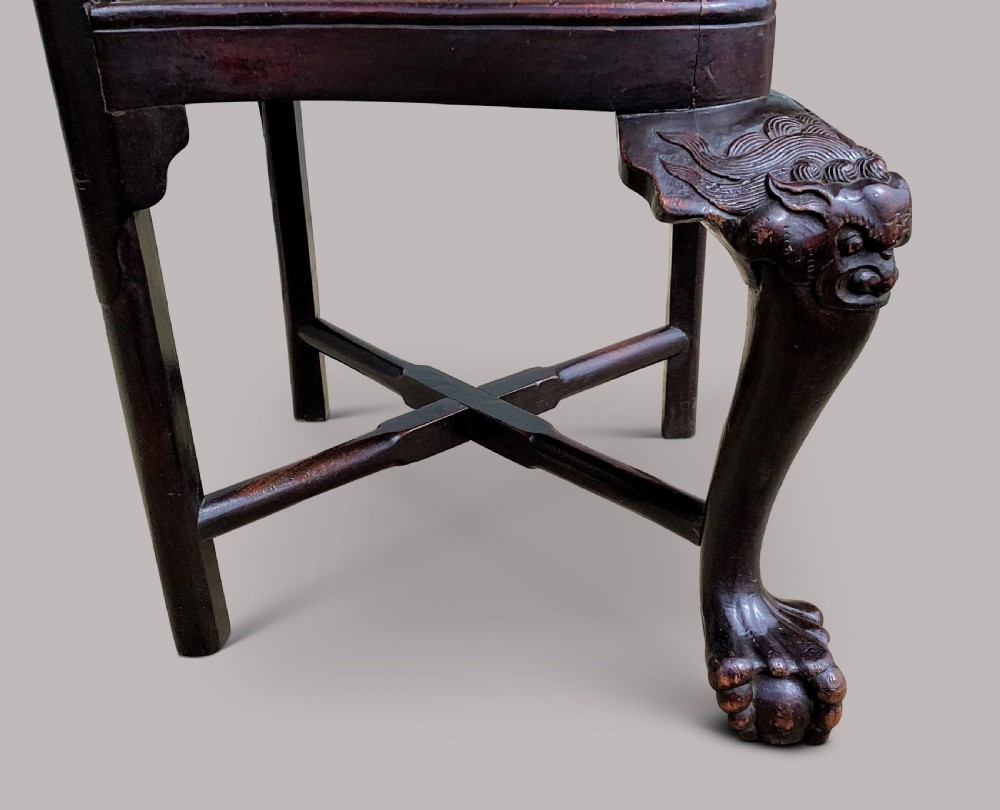 An 18th-century Chinese export dark hardwood corner armchair featuring a curved crest rail, carved splats, an olive green velvet seat, and a cabriole front leg with a carved mask and claw foot. View XXIII