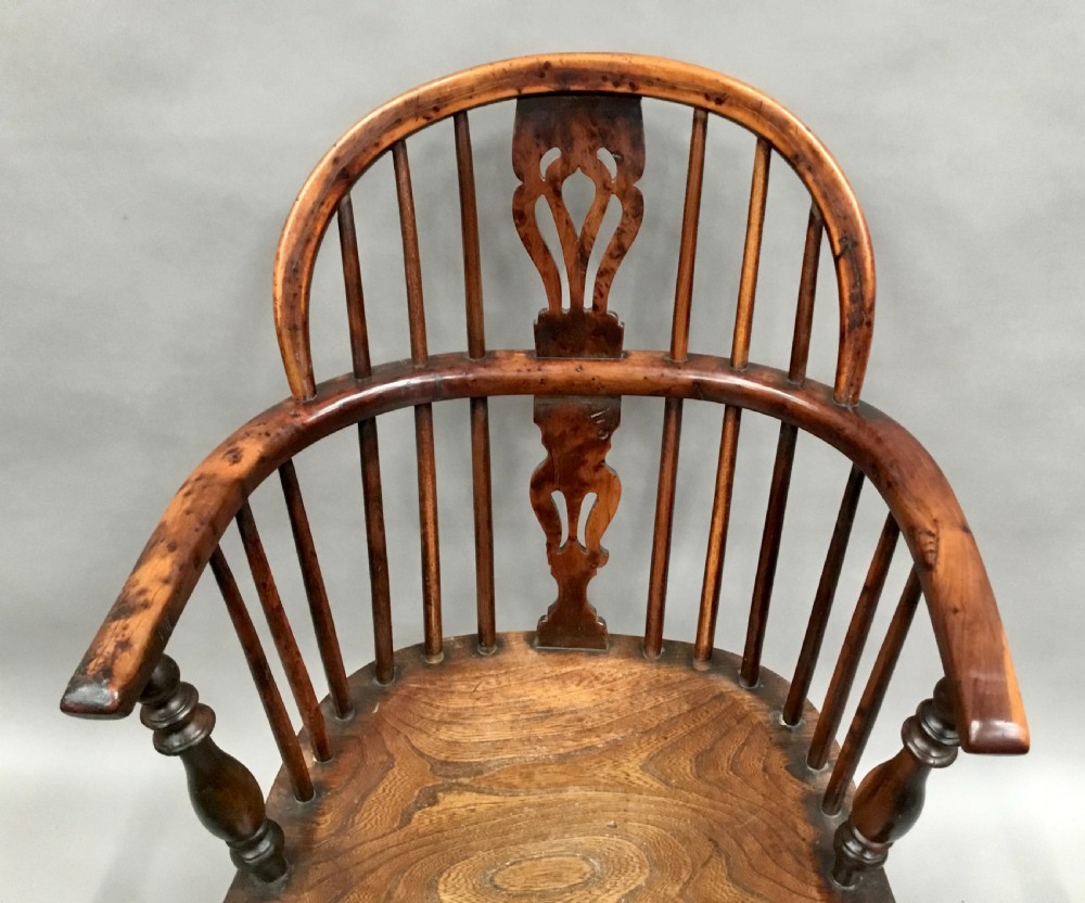 A pair of 19th-century hoop-back Windsor armchairs with pierced central splats, turned legs, curved stretchers, and richly patinated timber. View V