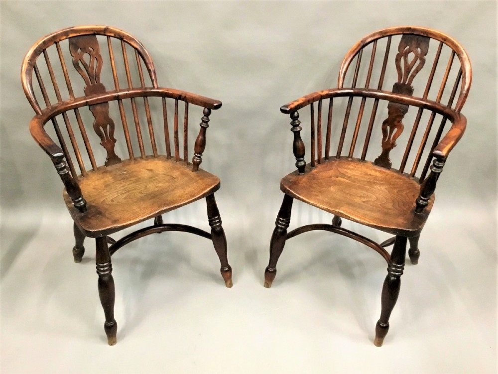 A pair of 19th-century hoop-back Windsor armchairs with pierced central splats, turned legs, curved stretchers, and richly patinated timber. View X