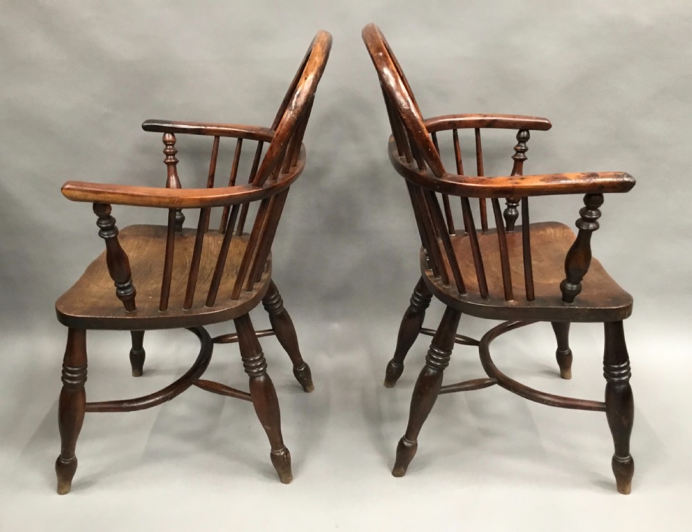 A pair of 19th-century hoop-back Windsor armchairs with pierced central splats, turned legs, curved stretchers, and richly patinated timber. View XX