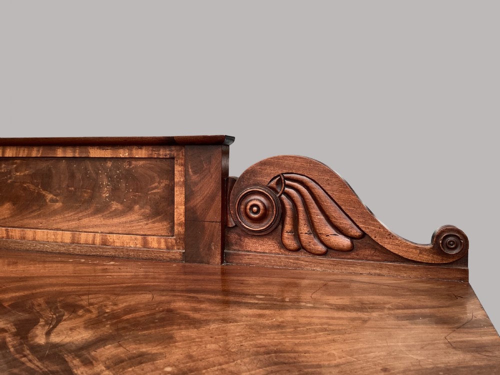A Regency flame mahogany serving table featuring carved monopodial legs with paw feet and a decorative scrolled cresting rail. View VIII