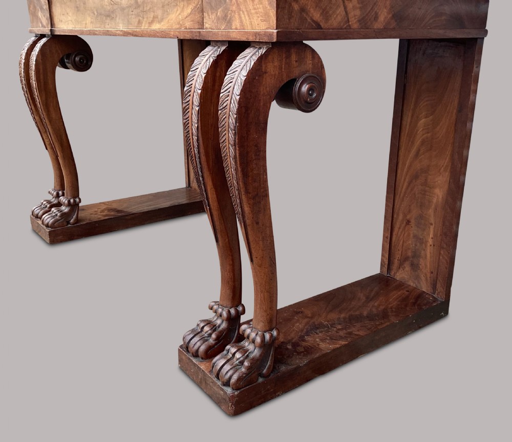 A Regency flame mahogany serving table featuring carved monopodial legs with paw feet and a decorative scrolled cresting rail. View XVIII