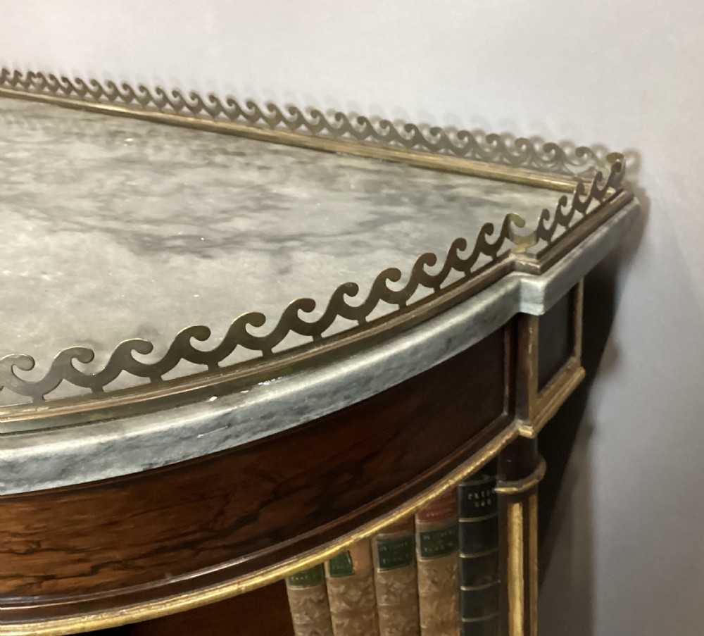 A Regency rosewood breakfront open cabinet featuring a marble top with a brass gallery, central open shelves flanked by faux leather book spines, and fluted gilt columns on tapered legs. View VIII