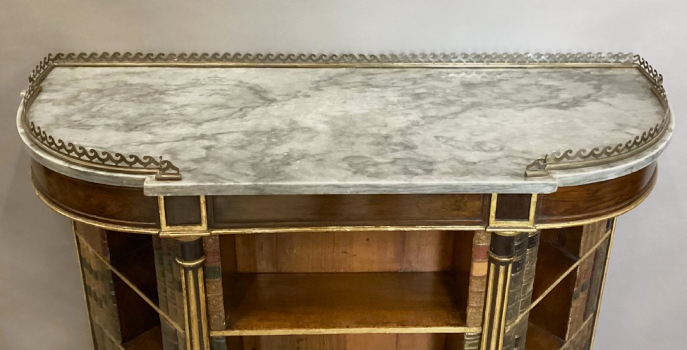 A Regency rosewood breakfront open cabinet featuring a marble top with a brass gallery, central open shelves flanked by faux leather book spines, and fluted gilt columns on tapered legs. View XVI