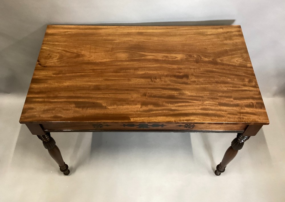 A Regency mahogany side table featuring ebony inlaid geometric scrollwork on the frieze and four reeded turned legs. View XVI