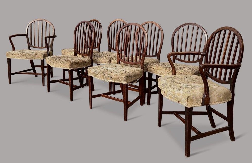 George III set of 8 mahogany dining chairs; with unusual backs in the Hepplewhite manner