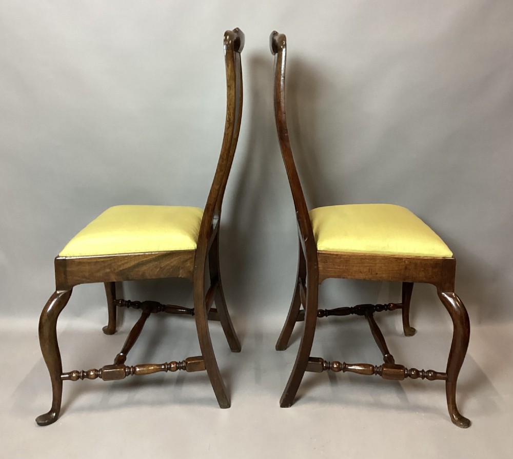 A pair of 18th-century Chinese Huanghuali side chairs featuring curved backsplats and yellow upholstered seats. View IX
