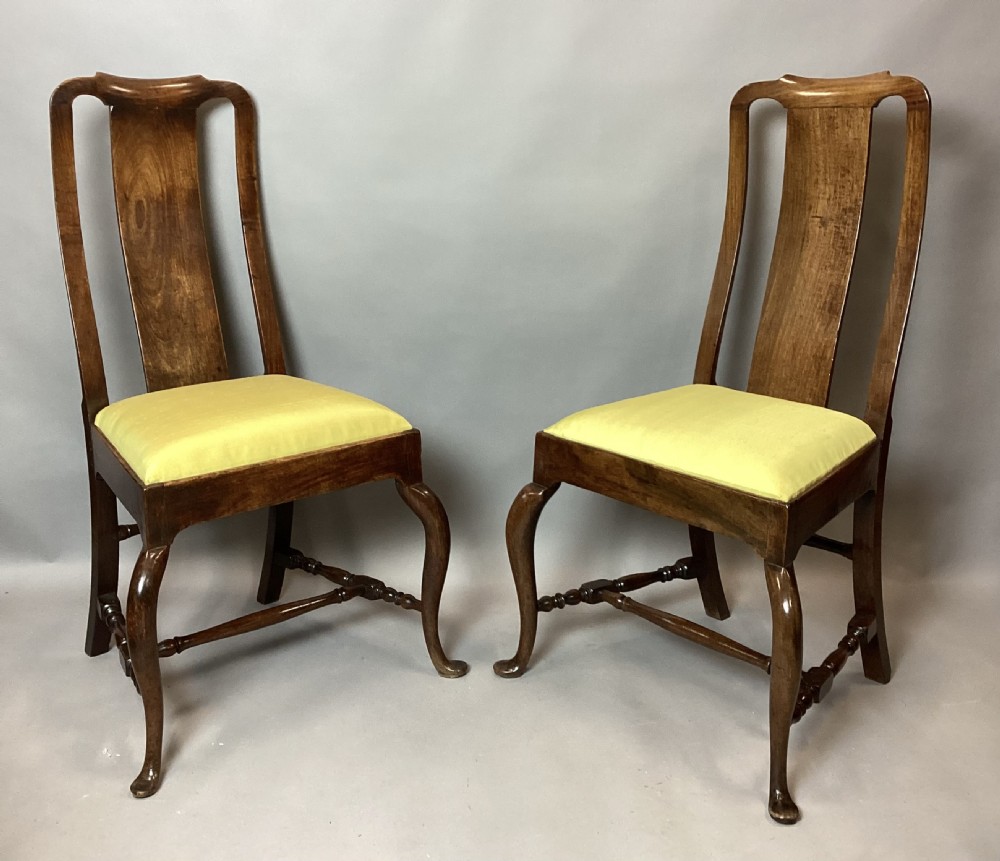 A pair of 18th-century Chinese Huanghuali side chairs featuring curved backsplats and yellow upholstered seats. View XII