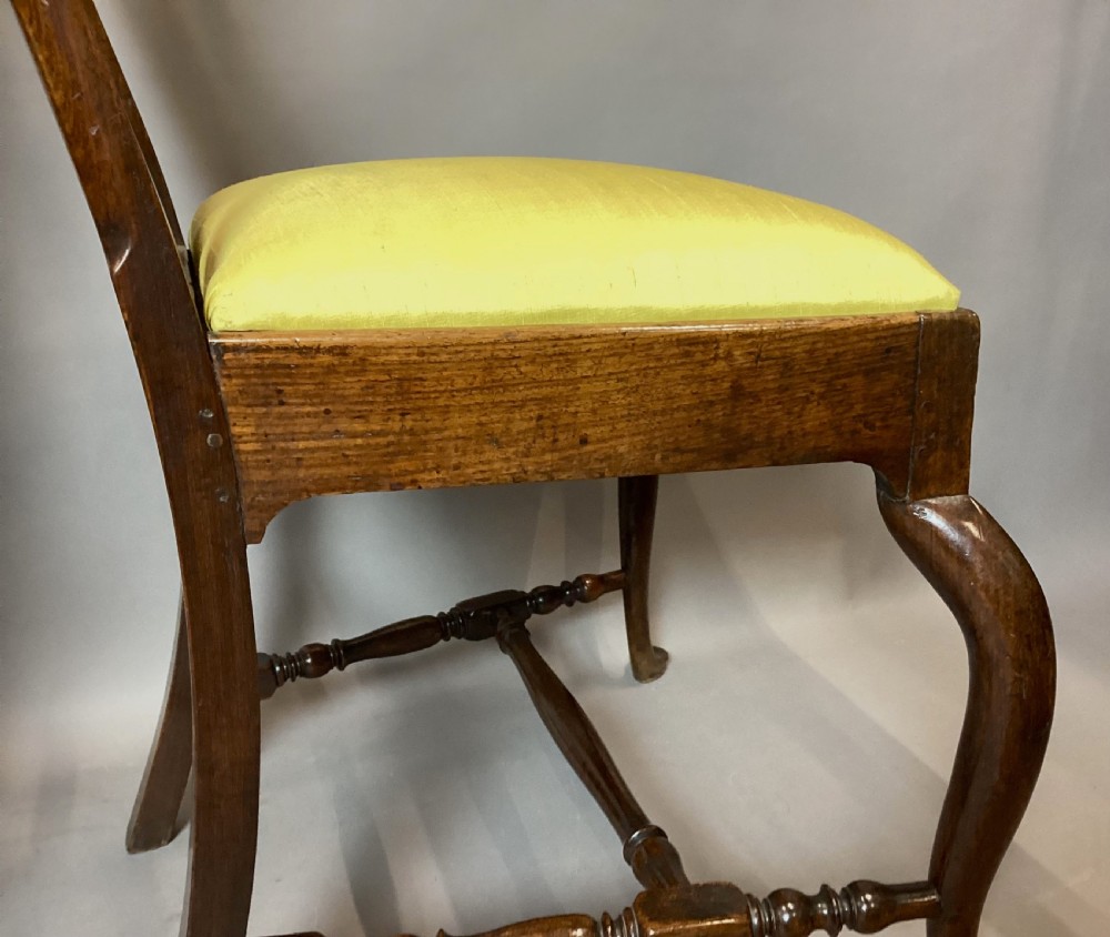 A pair of 18th-century Chinese Huanghuali side chairs featuring curved backsplats and yellow upholstered seats. View XXII