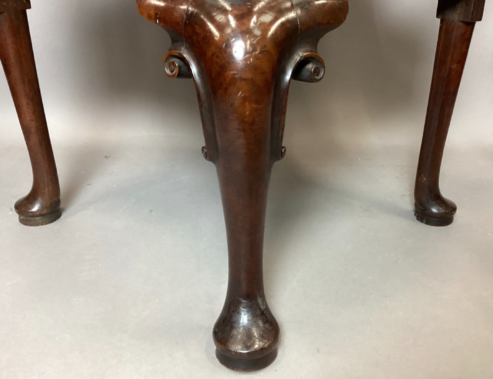 An antique George I walnut corner chair featuring a curved backrest, turned support posts, twin splats, a drop-in seat, and a central cabriole front leg. View XI