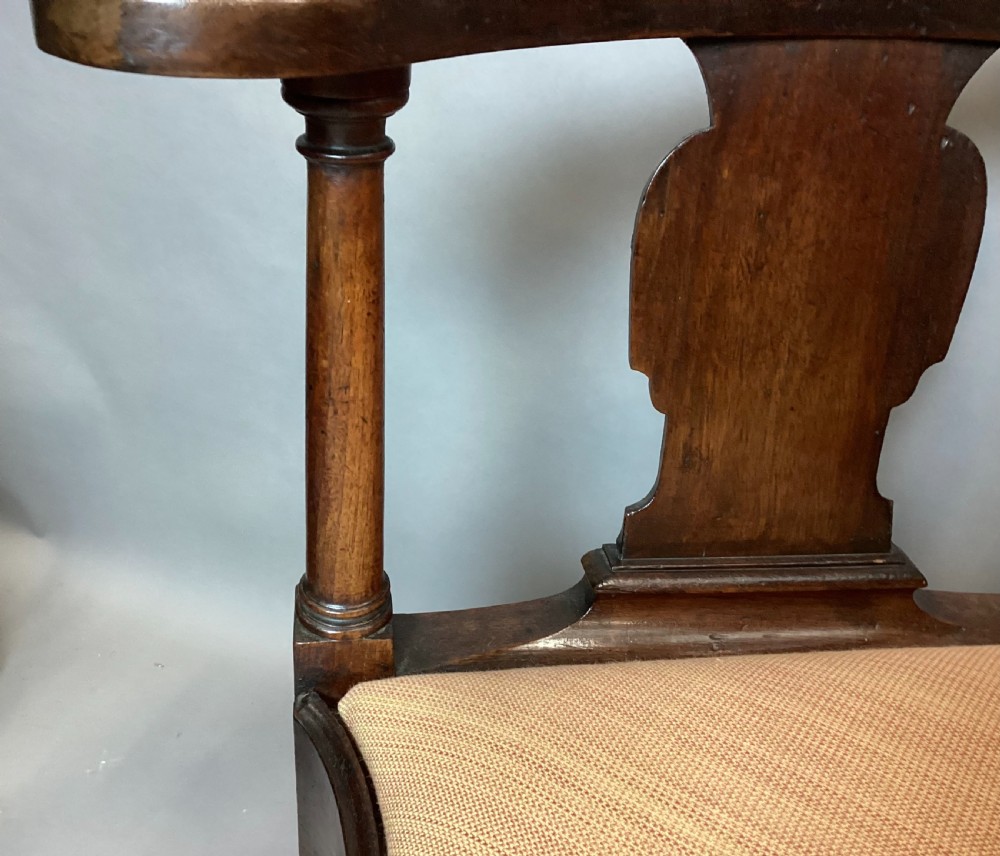 An antique George I walnut corner chair featuring a curved backrest, turned support posts, twin splats, a drop-in seat, and a central cabriole front leg. View XIV