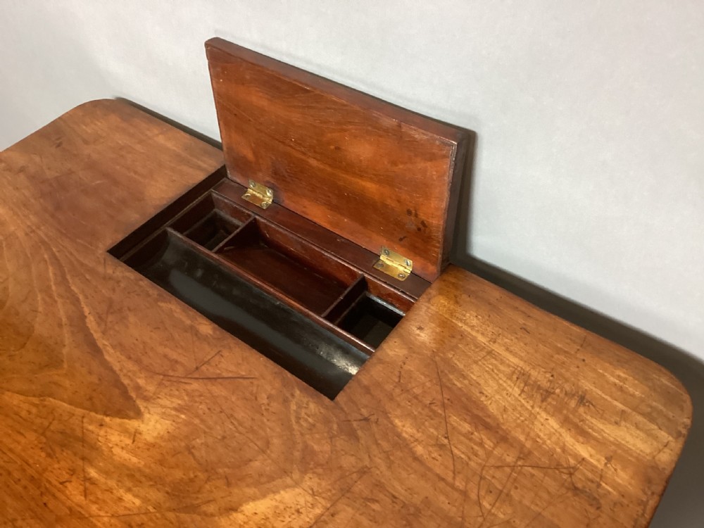 A Regency mahogany chamber writing table featuring an ebony-banded drawer front, reeded turned legs, and brass castors. View XVIII