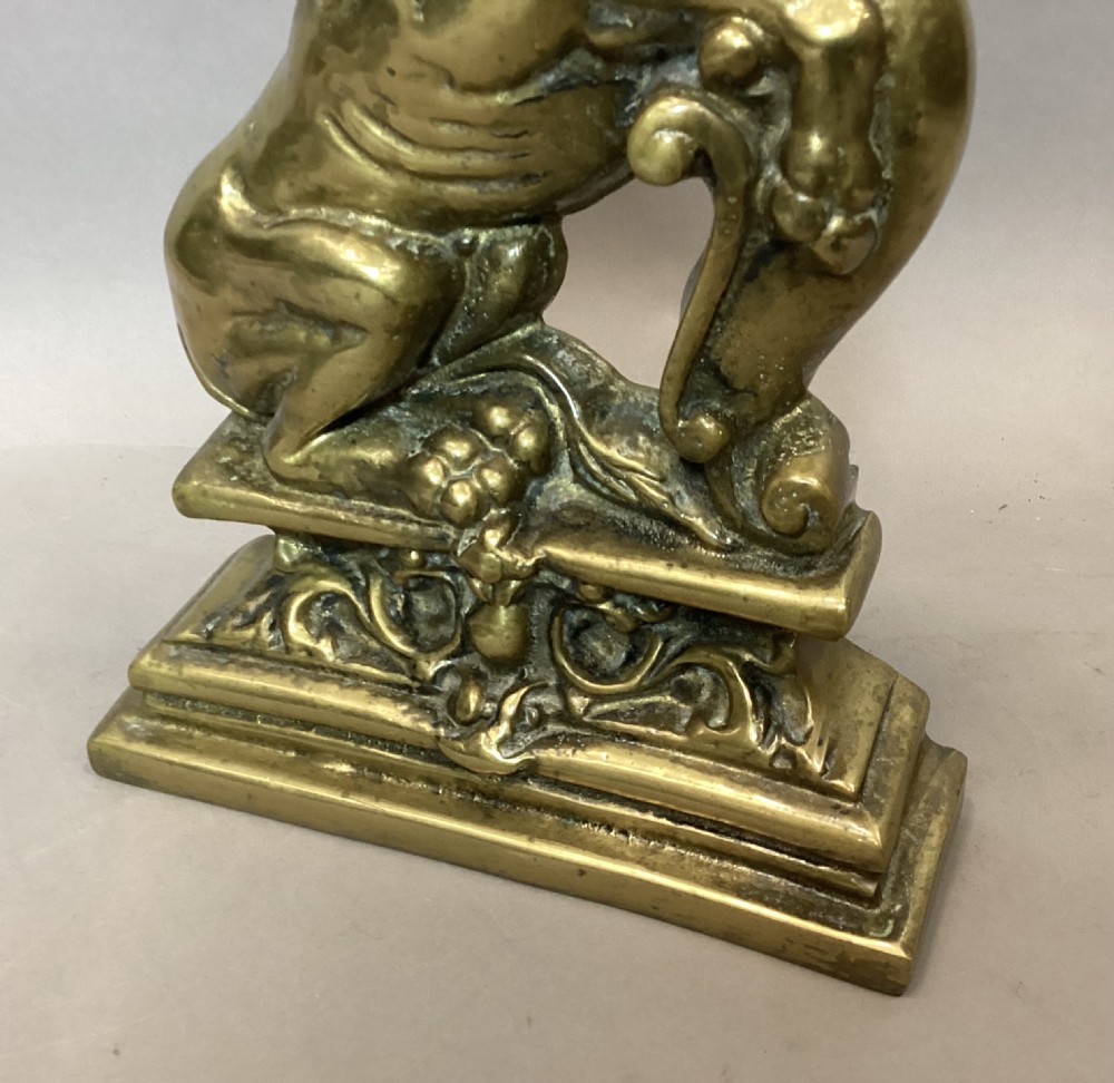 A pair of 19th-century cast brass doorstops featuring rampant lion figures set upon scrollwork bases. View VII
