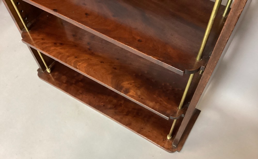 A four-tier Regency mahogany wall shelf unit featuring vertical brass support rods and top brass mounting brackets. View V