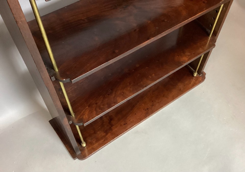 A four-tier Regency mahogany wall shelf unit featuring vertical brass support rods and top brass mounting brackets. View XII