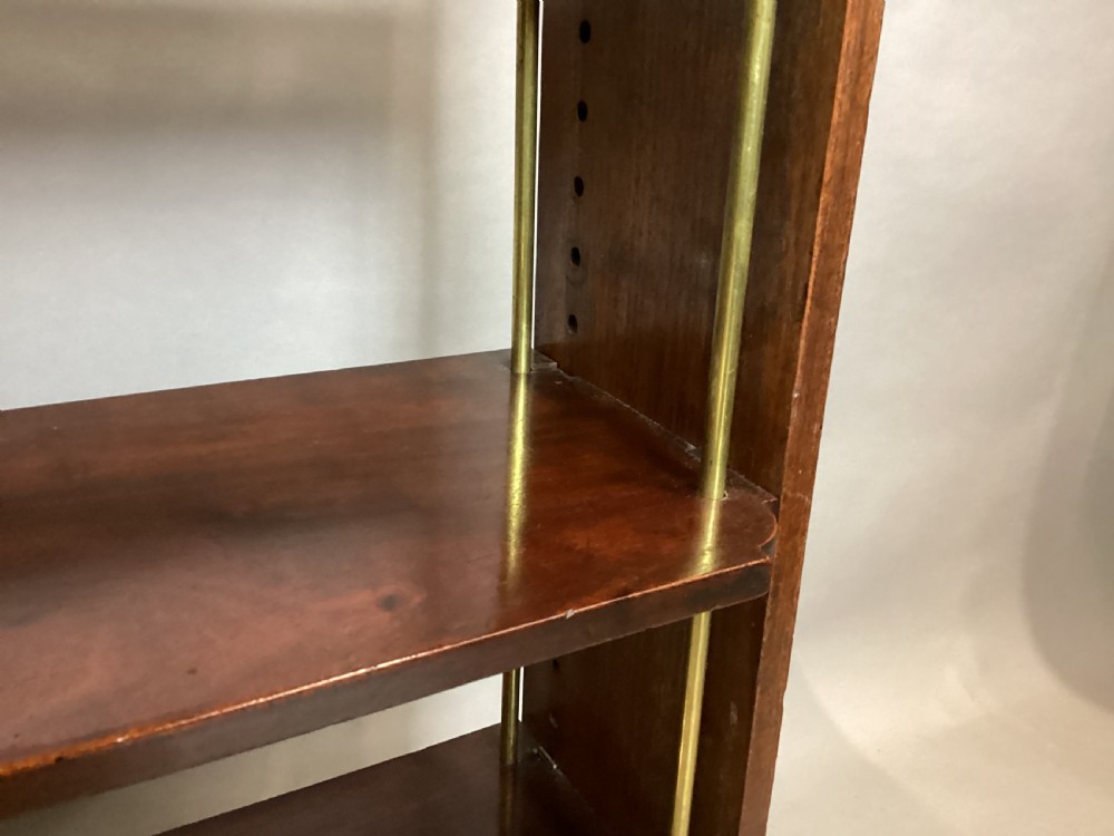 A four-tier Regency mahogany wall shelf unit featuring vertical brass support rods and top brass mounting brackets. View XVII