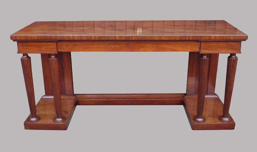 A Regency mahogany serving table featuring a polished rectangular top supported by twin reeded columns on plinth bases. View III