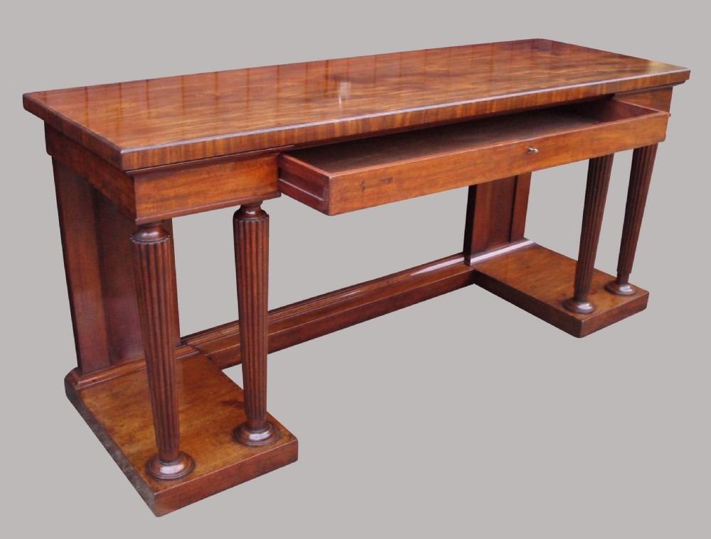 A Regency mahogany serving table featuring a polished rectangular top supported by twin reeded columns on plinth bases. View V