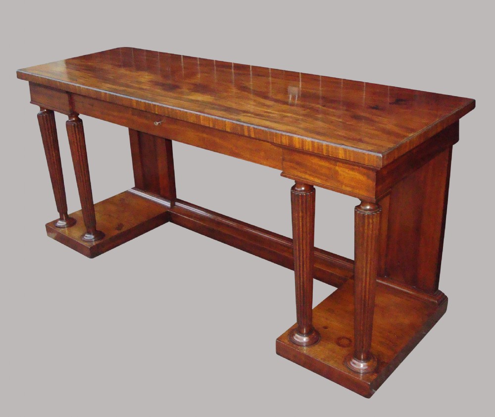 A Regency mahogany serving table featuring a polished rectangular top supported by twin reeded columns on plinth bases. View VI