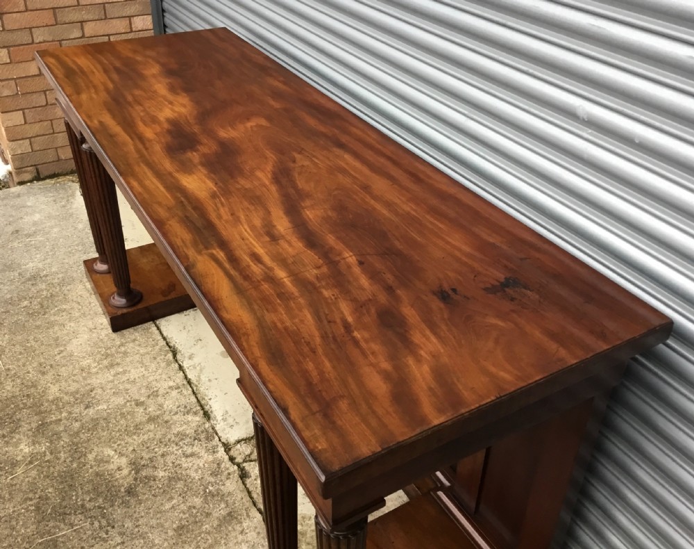 A Regency mahogany serving table featuring a polished rectangular top supported by twin reeded columns on plinth bases. View XIII