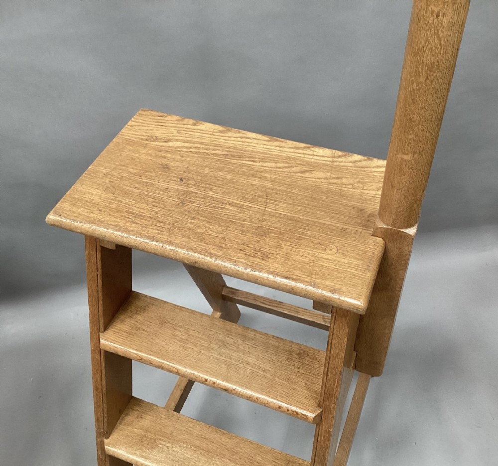 Nineteenth-century golden oak library steps featuring three treads, a top platform, an A-frame structure, and an integrated vertical hand pole. View II