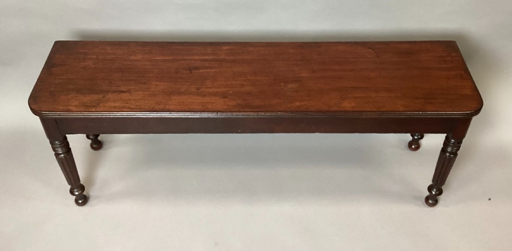 A long Regency mahogany hall bench featuring turned reeded legs, a rectangular solid top with rounded corners, and a polished dark timber finish. View VII