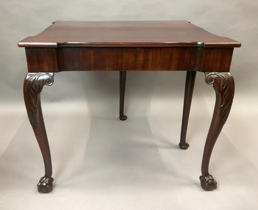 A George II mahogany fold-over tea table featuring carved cabriole legs with acanthus knees and claw-and-ball feet. View XIX