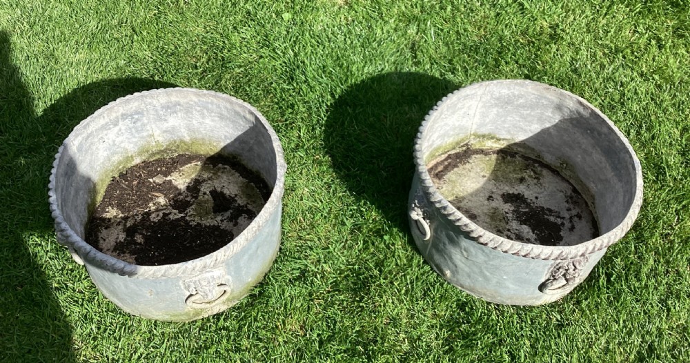 A pair of large cylindrical Regency lead garden planters featuring moulded rope-twist rims and relief lion mask ring handles with a weathered grey patina. View VIII