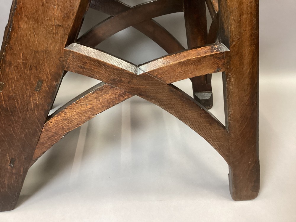 A nineteenth-century dark oak set of Gothic Revival library steps featuring four treads, arched bracing, and a tall vertical handrail. View IV