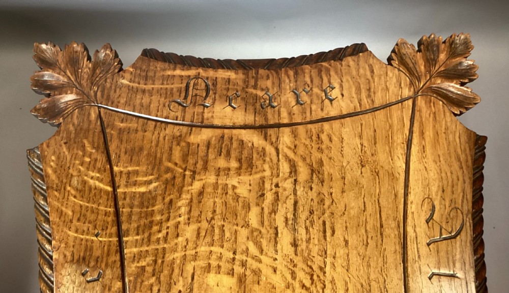 A Regency figured oak occasional table featuring carved acanthus corners, a rope-twist border, incised lettering detail, a turned central stem, and carved legs on castors. View VIII