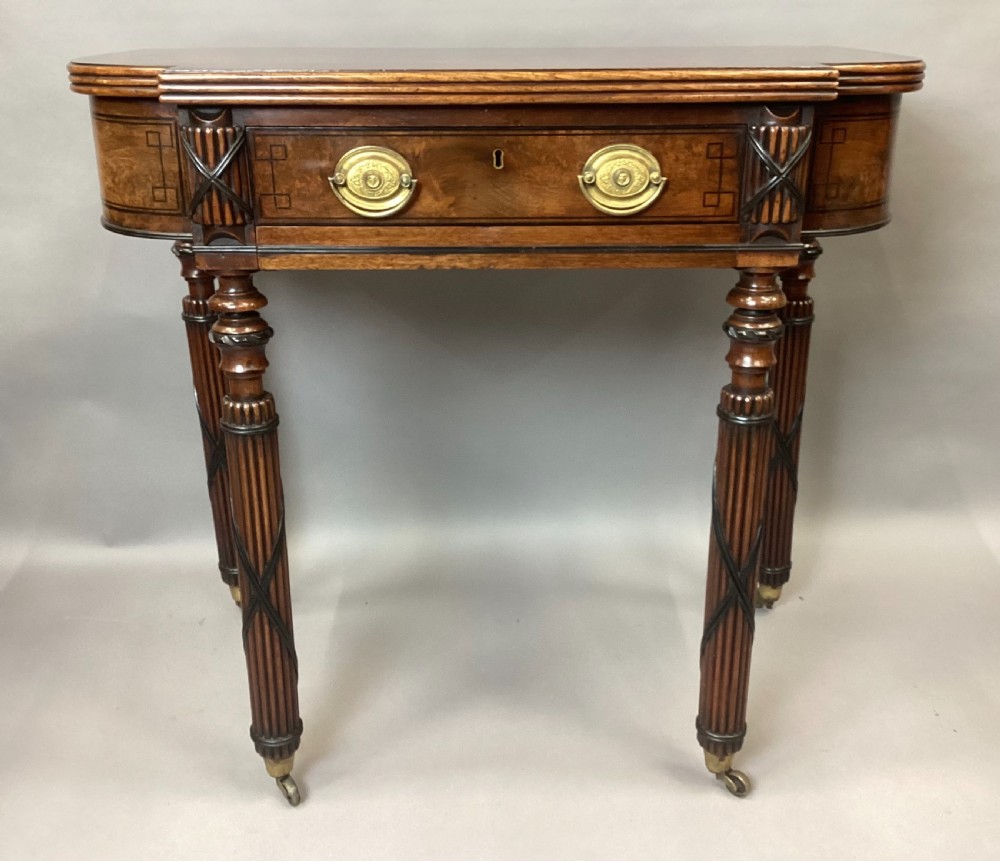 A Regency mahogany side table featuring ebony inlay details, turned spiral legs with brass castors, and a front drawer with circular brass handles. View II