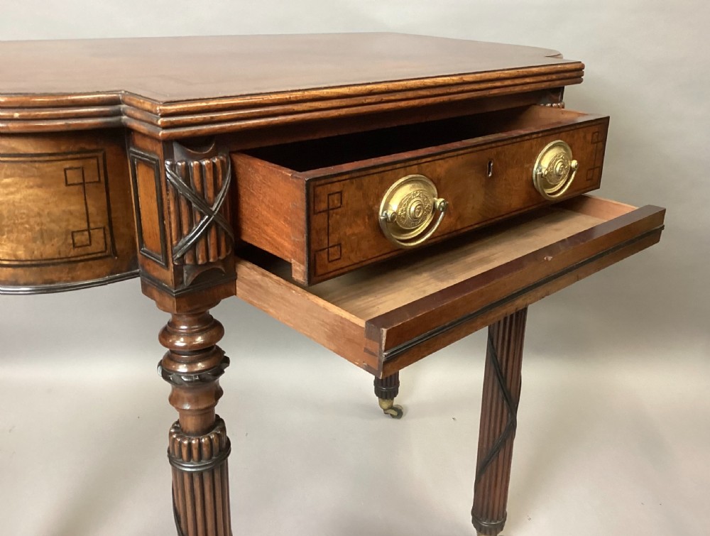 A Regency mahogany side table featuring ebony inlay details, turned spiral legs with brass castors, and a front drawer with circular brass handles. View III