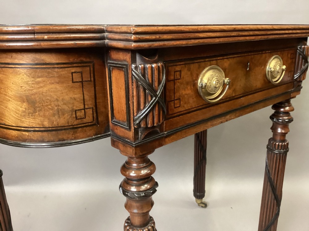 A Regency mahogany side table featuring ebony inlay details, turned spiral legs with brass castors, and a front drawer with circular brass handles. View XI