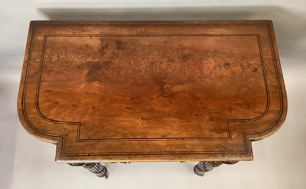 A Regency mahogany side table featuring ebony inlay details, turned spiral legs with brass castors, and a front drawer with circular brass handles. View XVI