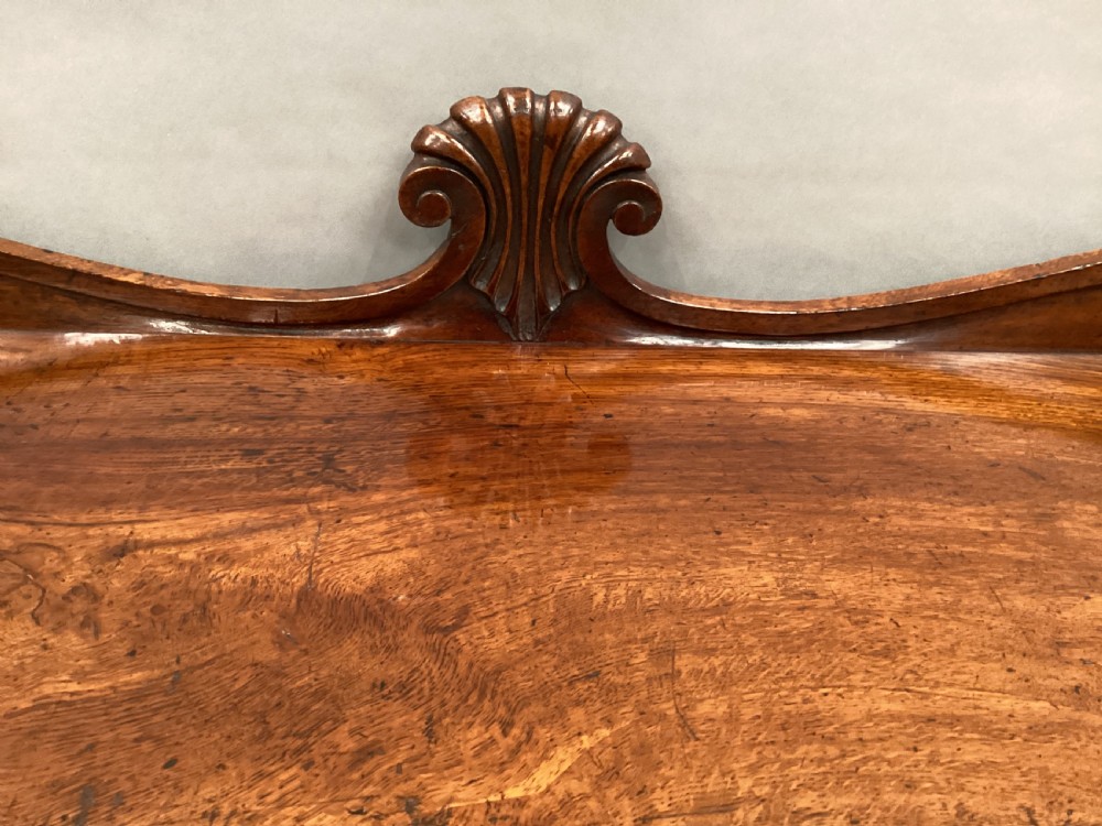 A Regency period side cabinet crafted from figured pollard oak featuring two panelled doors, a carved anthemion upstand, and a plinth base. View XIII