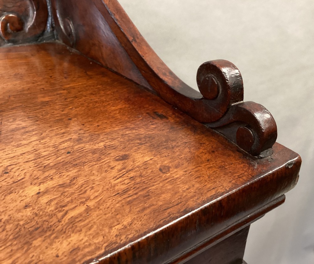 A Regency period side cabinet crafted from figured pollard oak featuring two panelled doors, a carved anthemion upstand, and a plinth base. View XVI