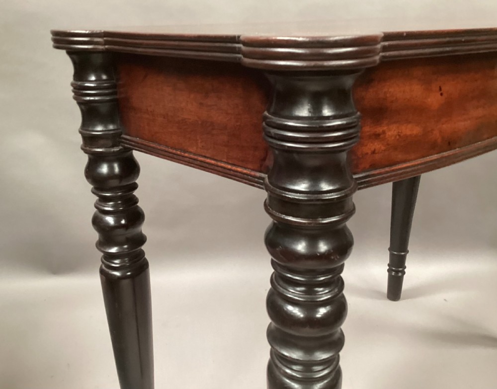 A George IV mahogany bowfront side table with a curved front apron and four turned ebonised legs. View VII