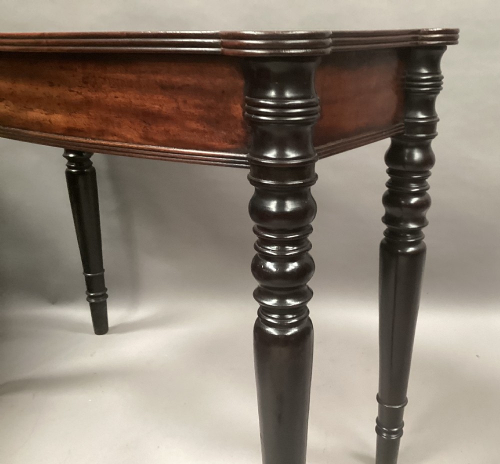 A George IV mahogany bowfront side table with a curved front apron and four turned ebonised legs. View VIII