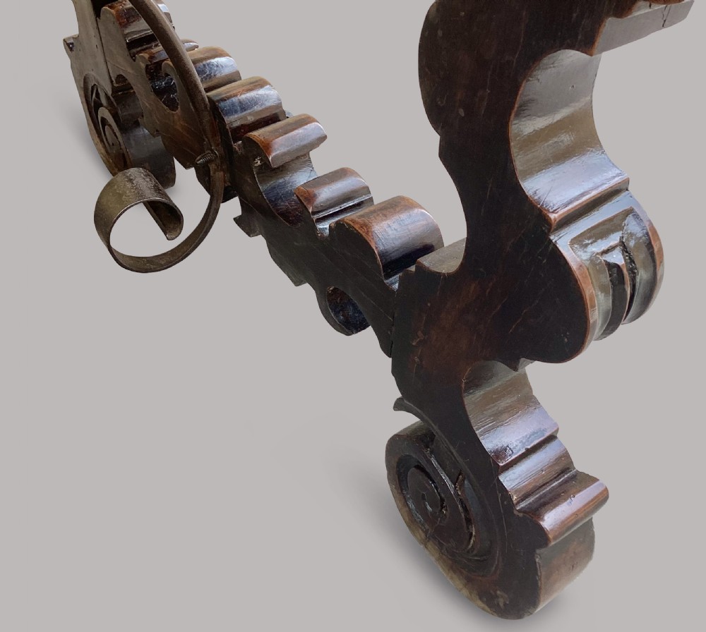 An 18th-century Spanish walnut and fruitwood centre table featuring carved trestle supports, decorative edge moulding, and wrought iron stretchers. View XVI