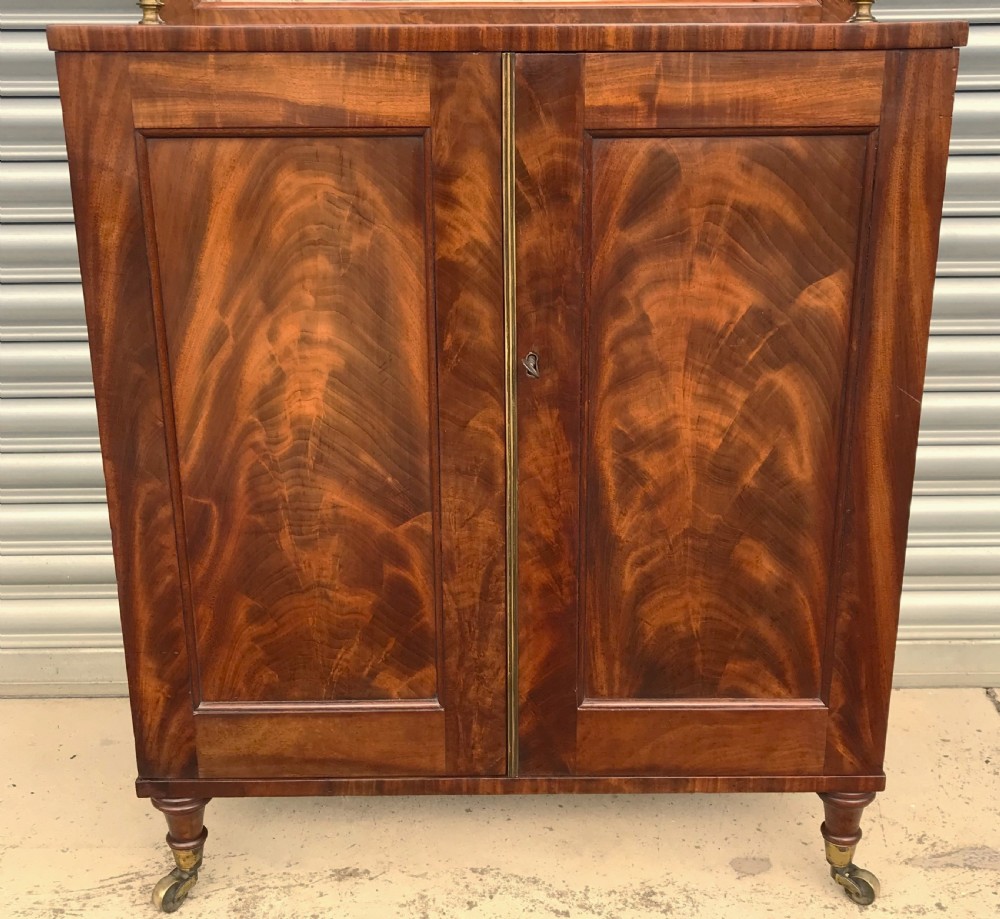 A Regency figured mahogany side cabinet with a top mirror shelf supported by brass spiral columns and topped with a brass gallery. View III