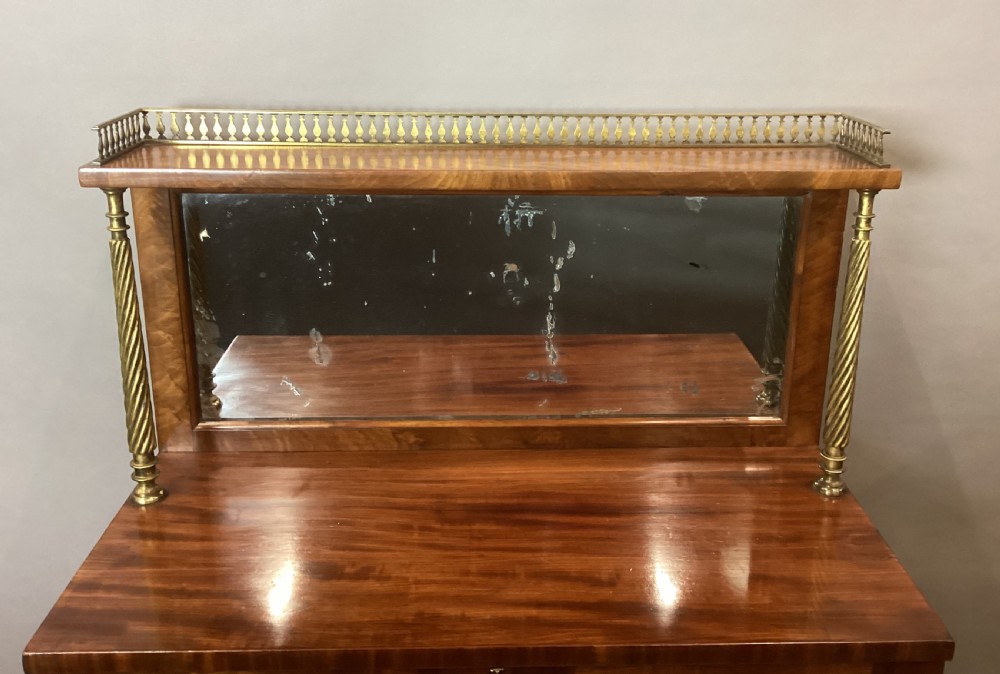 A Regency figured mahogany side cabinet with a top mirror shelf supported by brass spiral columns and topped with a brass gallery. View IV