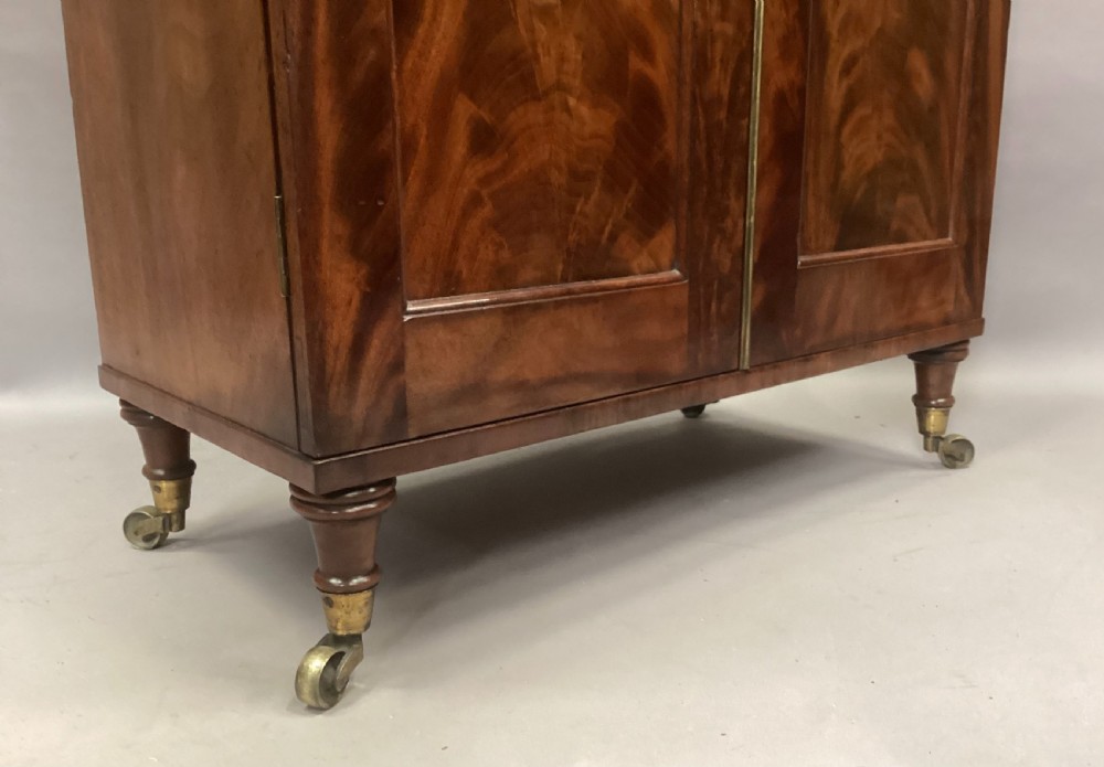 A Regency figured mahogany side cabinet with a top mirror shelf supported by brass spiral columns and topped with a brass gallery. View X