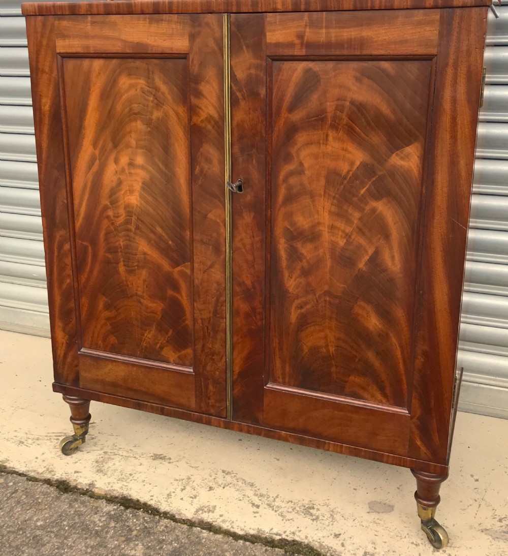 A Regency figured mahogany side cabinet with a top mirror shelf supported by brass spiral columns and topped with a brass gallery. View XV