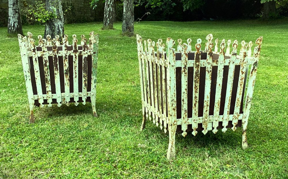 A pair of square 19th-century wrought iron strapwork planters with distressed cream paint, finial borders, and solid metal liners. View VI