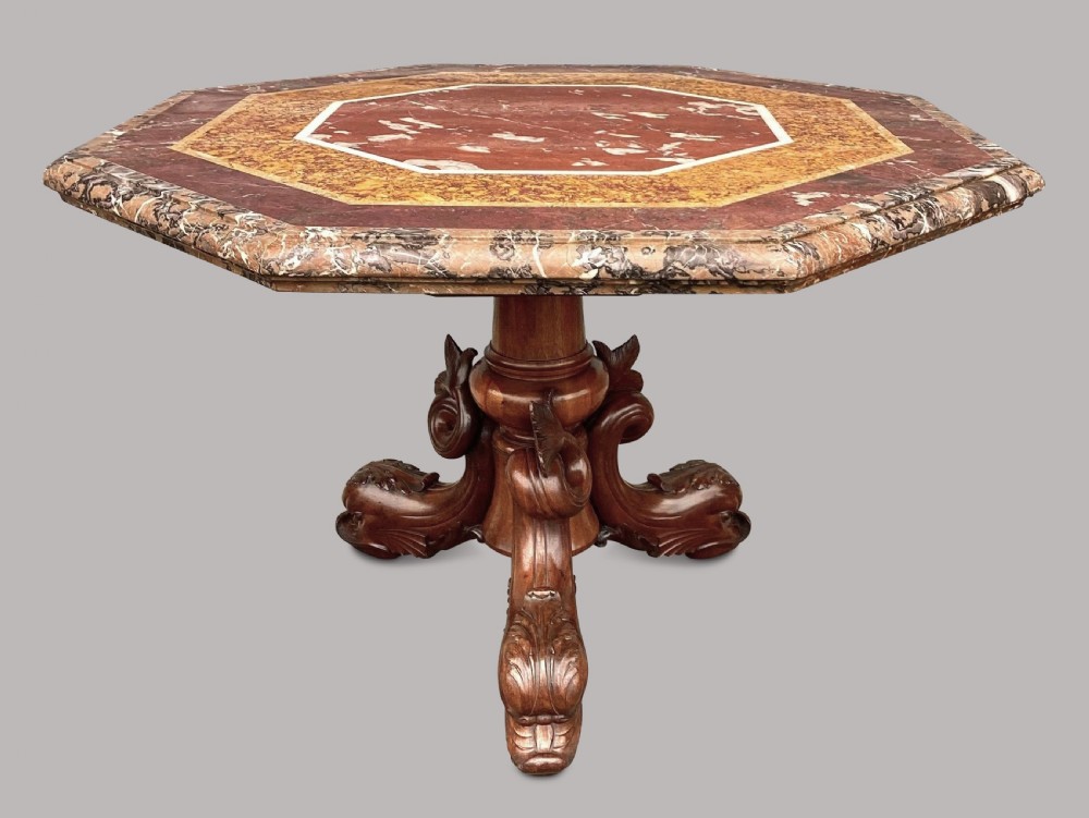 An octagonal 19th-century centre table with a geometric inlaid specimen marble top supported on a carved walnut pedestal base with scroll feet. View IV