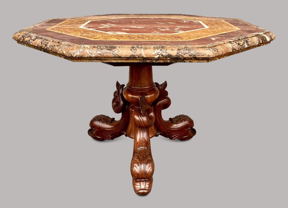 An octagonal 19th-century centre table with a geometric inlaid specimen marble top supported on a carved walnut pedestal base with scroll feet. View VI