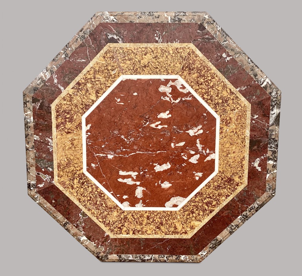 An octagonal 19th-century centre table with a geometric inlaid specimen marble top supported on a carved walnut pedestal base with scroll feet. View VIII