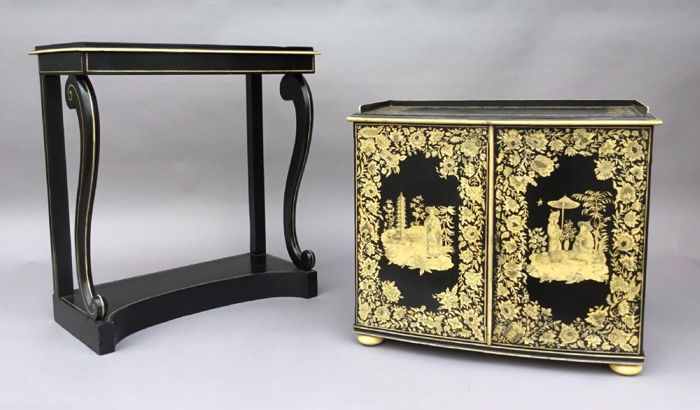 A Regency black lacquered collectors cabinet on stand featuring detailed cream and gilt Chinoiserie penwork illustrations of oriental figures and floral borders. View IV